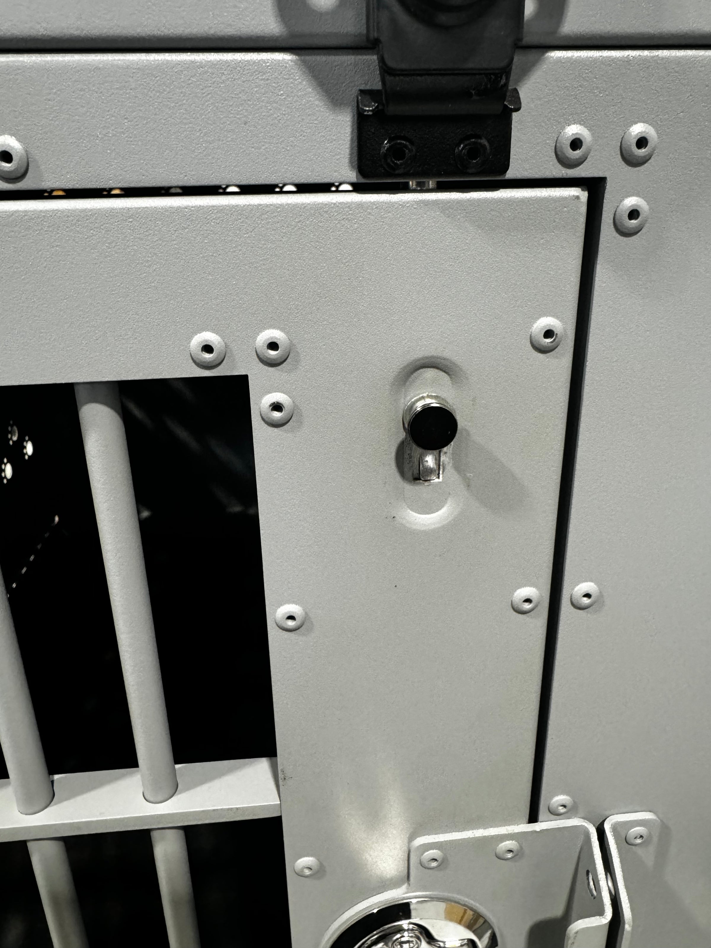 Medium grey K&J crate in an industrial building, showcasing a close-up of the new internal door deadbolts for added security.